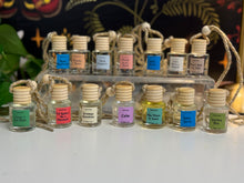 Load image into Gallery viewer, Car Diffuser Small glass bottles with wooden caps on a white surface, each labeled with a different name.
